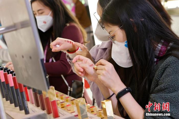 圖為女生正在體驗(yàn)口紅產(chǎn)品。 殷立勤 攝